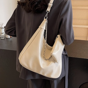 Chic butter yellow hobo tote bag with silver chain and mini pouch on grey blazer