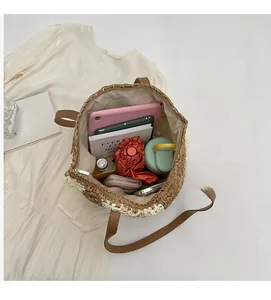 Vue de dessus d'un grand sac cabas en paille montrant l'intérieur spacieux et la fermeture