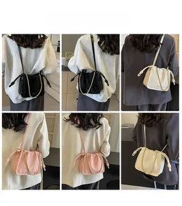 Three-color bucket bags with drawstring closure and gold chain straps on models