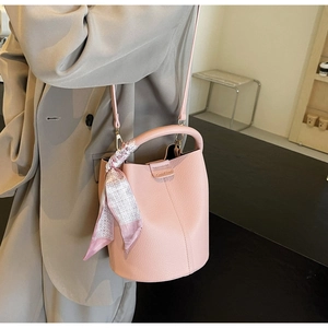 Pink lychee grain leather bucket bag with silk scarf detail and brand logo engraving