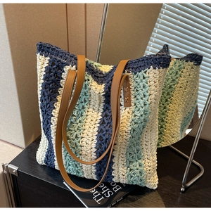 Détail d'un grand sac cabas en paille tissée multicolore avec anses en cuir marron