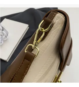 Detailed macro view of the gold-plated metal clasp on a bicolor vintage bucket bag