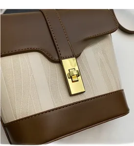 Detail of golden metal buckle on brown leather and woven bucket bag with wave texture