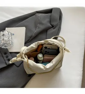 Macro view of creamy white bucket bag interior showing large capacity and zipper pocket