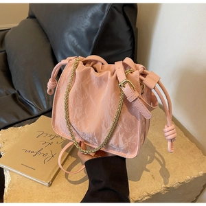 Detail of pink marble-textured bucket bag with drawstring and golden chain strap