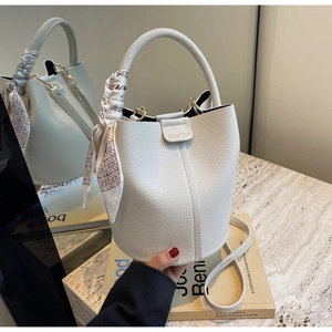 Detail of white lychee-patterned bucket bag with decorative scarf and Chio' 2nd logo