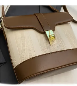Close-up of retro bucket bag with cream textured fabric and brown leather flap