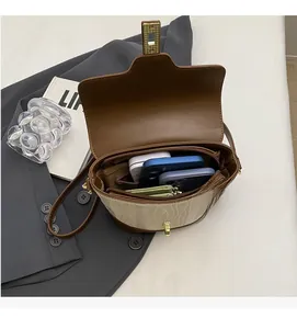Detail of the multi-compartment interior and metal lock of a retro leather bucket bag