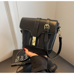 Detail of black bucket bag featuring golden twist lock and textured side panels