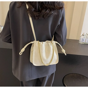 Detail of white pleated bucket bag with gold chain strap and miao & sha logo