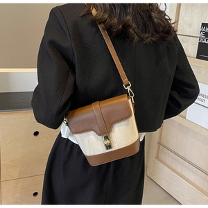 Brown leather and cream fabric bucket bag detail with golden metal clasp and strap