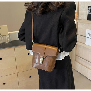 Detail shot of vintage dark brown bucket bag with wavy embossed texture and gold lock
