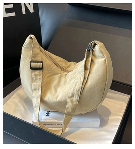 Détail du sac bandoulière croissant beige en nylon avec sangle à boucle réglable