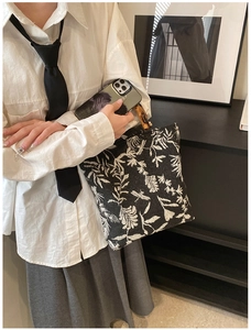 Détail de broderie florale sur sac en toile avec poignée en bambou sur un mannequin