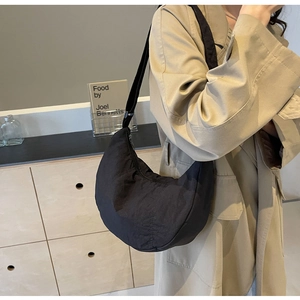 Vue détaillée du sac croissant en nylon noir avec texture froissée et large bandoulière