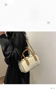 Detail view of two-tone Boston bag showing textured faux leather and adjustable shoulder strap