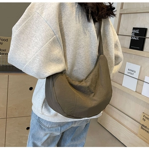 Détail d'un grand sac bandoulière en nylon en forme de croissant au style minimaliste