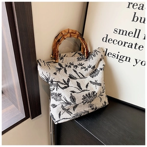 Détail du sac cabas en toile avec imprimé floral et poignées rétro en bambou brun
