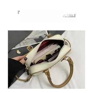 Interior view of bicolor Boston handbag showing large capacity and red fabric lining