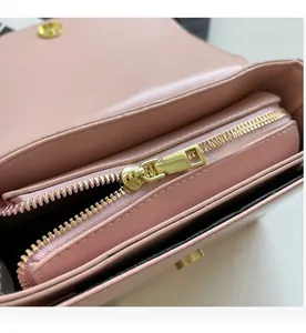 Close-up of the smooth golden zipper and pink leather interior of this crossbody bag