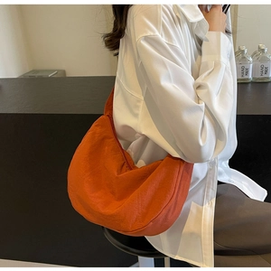 Sac hobo en nylon orange sur un modèle, sac à bandoulière en demi-lune de style minimaliste