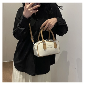 Detail of cream Boston bag with brown handles and Fashion&bag brand plate