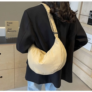 Gros plan du sac en nylon beige en forme de croissant avec bandoulière réglable