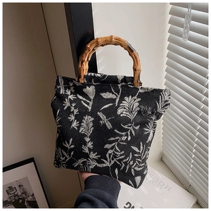 Détail du sac cabas en toile à motif floral avec des poignées en bambou élégantes