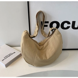 Détail du sac croissant en nylon beige avec bandoulière réglable et fermeture éclair