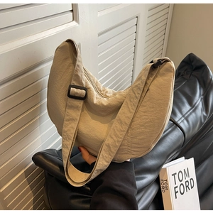 Détail de la boucle réglable et de la texture en nylon du sac à bandoulière croissant