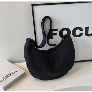 Détail du sac bandoulière en nylon noir en forme de croissant avec sangle réglable et zip