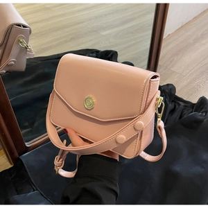 Detail of pink faux leather flap bag with gold C-logo metal buckle and round rivet handle