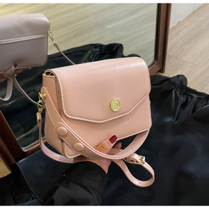 Detailed shot of pink faux leather bag with gold floral clasp and wide strap