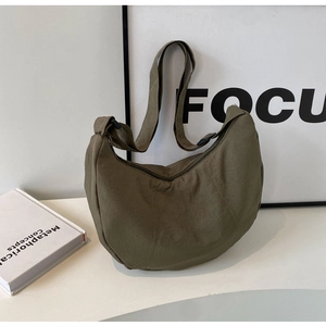 Détail du sac demi-lune en nylon vert olive avec bandoulière large et fermeture éclair noire