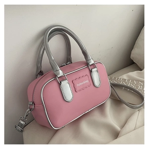 Detailed shot of pink Boston bag with silver handles and contrast trim detailing
