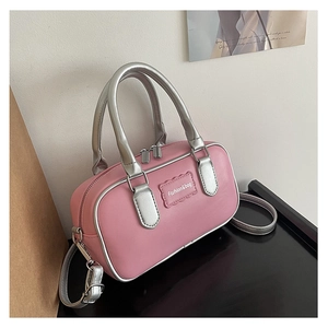 Detail of pink and silver boston bag with dual handles and detachable shoulder strap