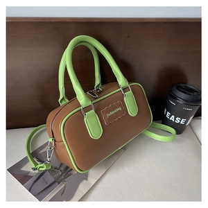 Detail of Boston bag showing brown leather texture and green edge contrast finish
