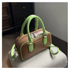 Detail of Boston-style brown bag with neon green accents and Fashion&bag label