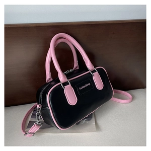 Detail view of pink trim and Fashion&bag logo on a black leather Boston box bag