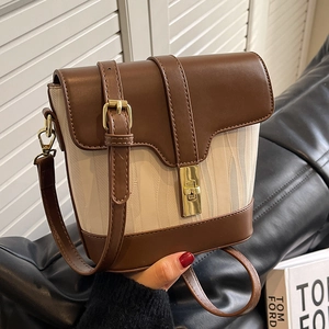 Retro bucket bag with brown leather trim and off-white woven fabric in a lifestyle setting