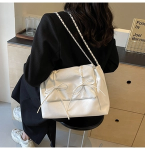 Détail de la texture en cuir blanc plissé et des nœuds sur ce sac à bandoulière