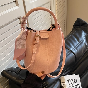 Chic pink pebble leather bucket bag with decorative silk scarf and adjustable strap