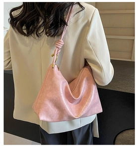 Back view of a pink hobo bag featuring knotted strap and golden metal hardware details