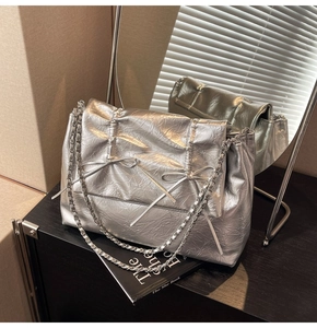 Détail du sac cabas argenté avec cuir froissé, nœuds et bandoulière en chaîne