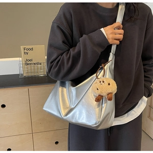 Details der silbernen Halbmond-Tasche mit Plüsch-Anhänger und verstellbarem Gurt