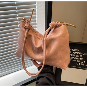 Pink faux leather tote bag featuring a decorative knot strap and zipper closure details