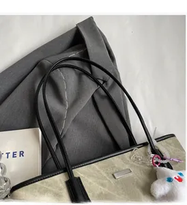 Détail du sac cabas en toile avec bordure noire et breloque étoile en peluche