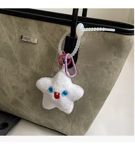 Gros plan d'un pendentif étoile en peluche avec visage mignon sur un sac fourre-tout