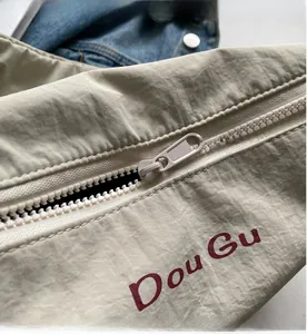Detailed macro view of the smooth beige nylon fabric zipper and red Dou Gu lettering
