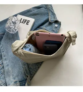 Detail view of the spacious interior of a beige canvas shoulder bag with multiple pockets